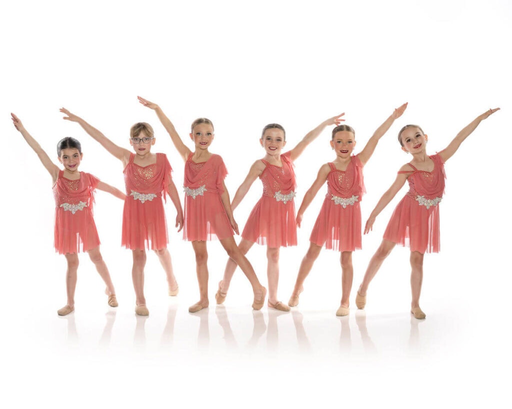 Lyrical dancers posing in front of white background.