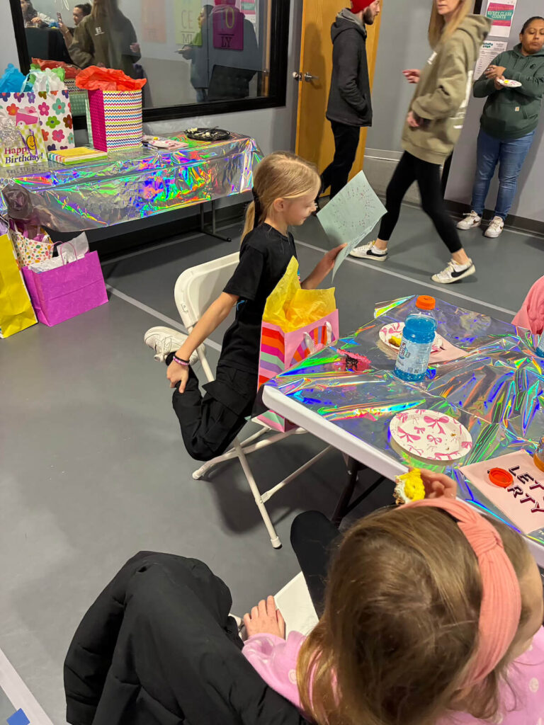 Young girl celebrating her birthday party at Prestige Dance Studio in Cedar Rapids. Opening birthday card.